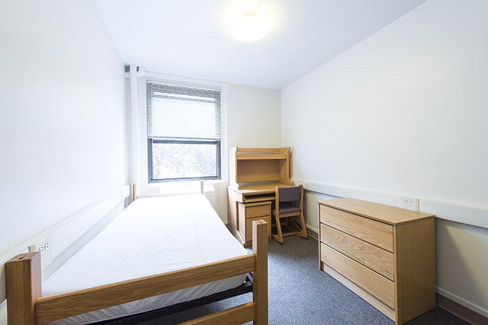 Scobell House Traditional Single - a bed a desk a dresser and a window